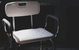 Plastic bathing chair for elder or disabled people showering put in dark letting light come from left side